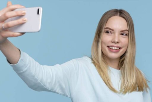girl taking selfie of herself with blue background