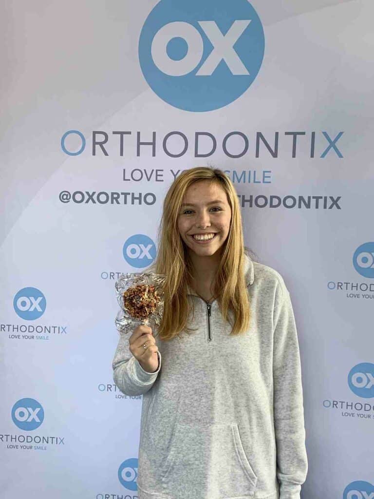 girl patient at OX Orthodontix holding a candy apple