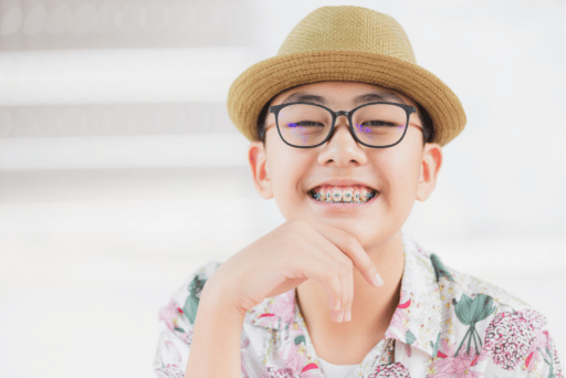 pre-teen with braces with glasses and hat