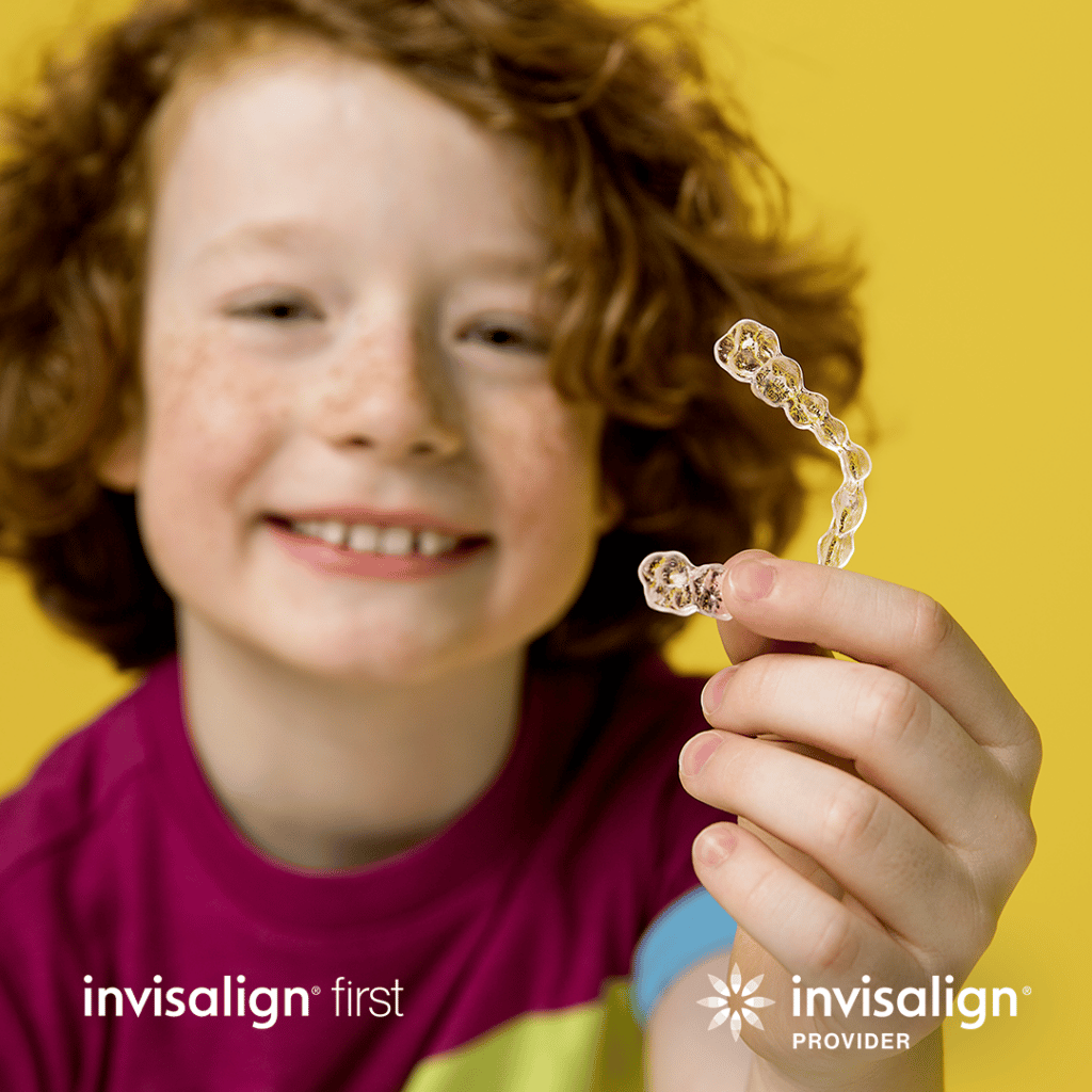 red headed child holding Invisalign